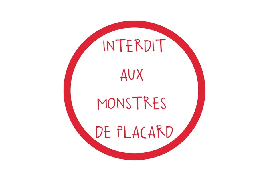 Panneau rond : un large cercle rouge sur fond blanc, portant en lettres manuscrites rouges « Interdit aux monstres de placard ».